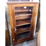 A 55.5cm Edwardian walnut pier cabinet with a low raised back and shelves enclosed by a glazed panel