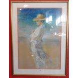 A gilt framed pastel drawing, depicting a woman wearing a hat on a beach - indistinctly signed