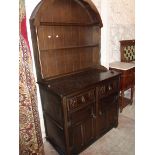 A 97cm reproduction dark stained oak dome top two part dresser with two shelf open plate rack over a