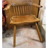 An antique mixed wood bow back country chair with thick moulded solid seat, set on simple turned and