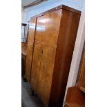A 1.48m 1930's walnut book match veneered Aw-lyn triple wardrobe with hanging space, shelves and