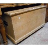 An 89cm Victorian pine lift top box with flanking iron carrying handles, set on Shepherd casters