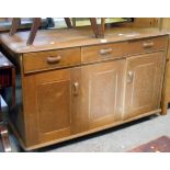 A 1.22m mixed wood Ercol style sideboard with three frieze drawers over bi-folding and single