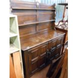 A 1.22m Ercol dark stained elm two part dresser with two shelf open plate rack over a base