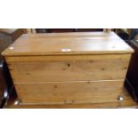 A 61cm old waxed pine lift top box with drawer under and flanking iron carrying handles