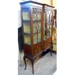 A 1.23m Edwardian mahogany and strung break bow front display cabinet with material lined interior