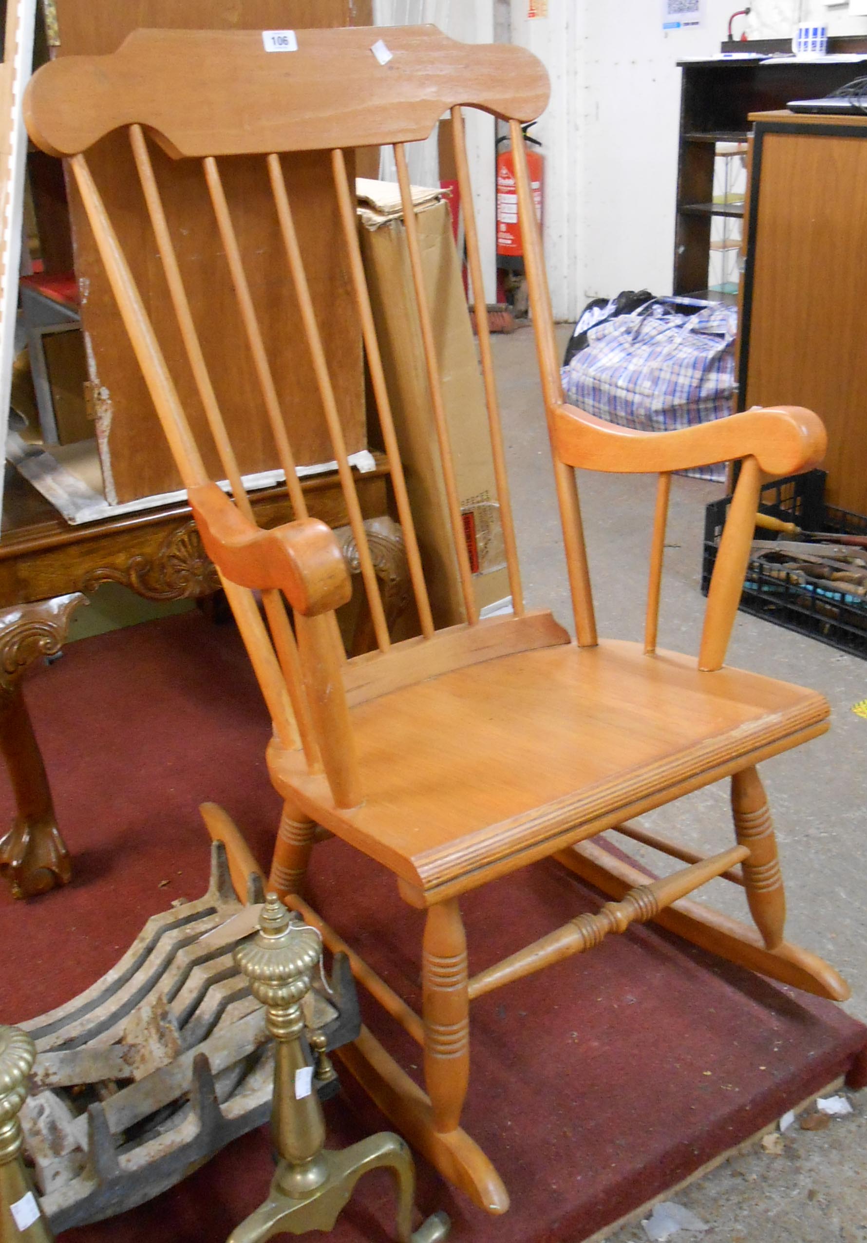 A modern stained wood high stick back rocking chair with laminated seat and turned supports