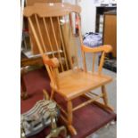 A modern stained wood high stick back rocking chair with laminated seat and turned supports