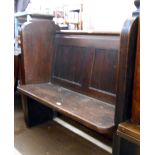 A 1.06m late Victorian stained pitch pine church pew with moulded and reeded sides with large iron