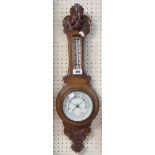 A late Victorian polished carved oak cased banjo barometer/thermometer with ceramic dial and aneroid