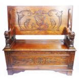 A 1.06m 20th Century polished oak monk's bench with carved decoration, flanking lion pattern