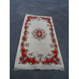 A wool rug with central medallion and floral border on cream ground - size on request