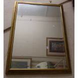 A 57cm antiqued gilt framed bevelled oblong wall mirror