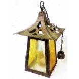 An Arts & Crafts beaten copper and brass hanging hall lantern with two-colour amber frosted glass
