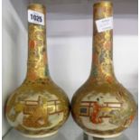 A pair of late Satsuma bottle vases profusely decorated in gilt and enamels with central panels