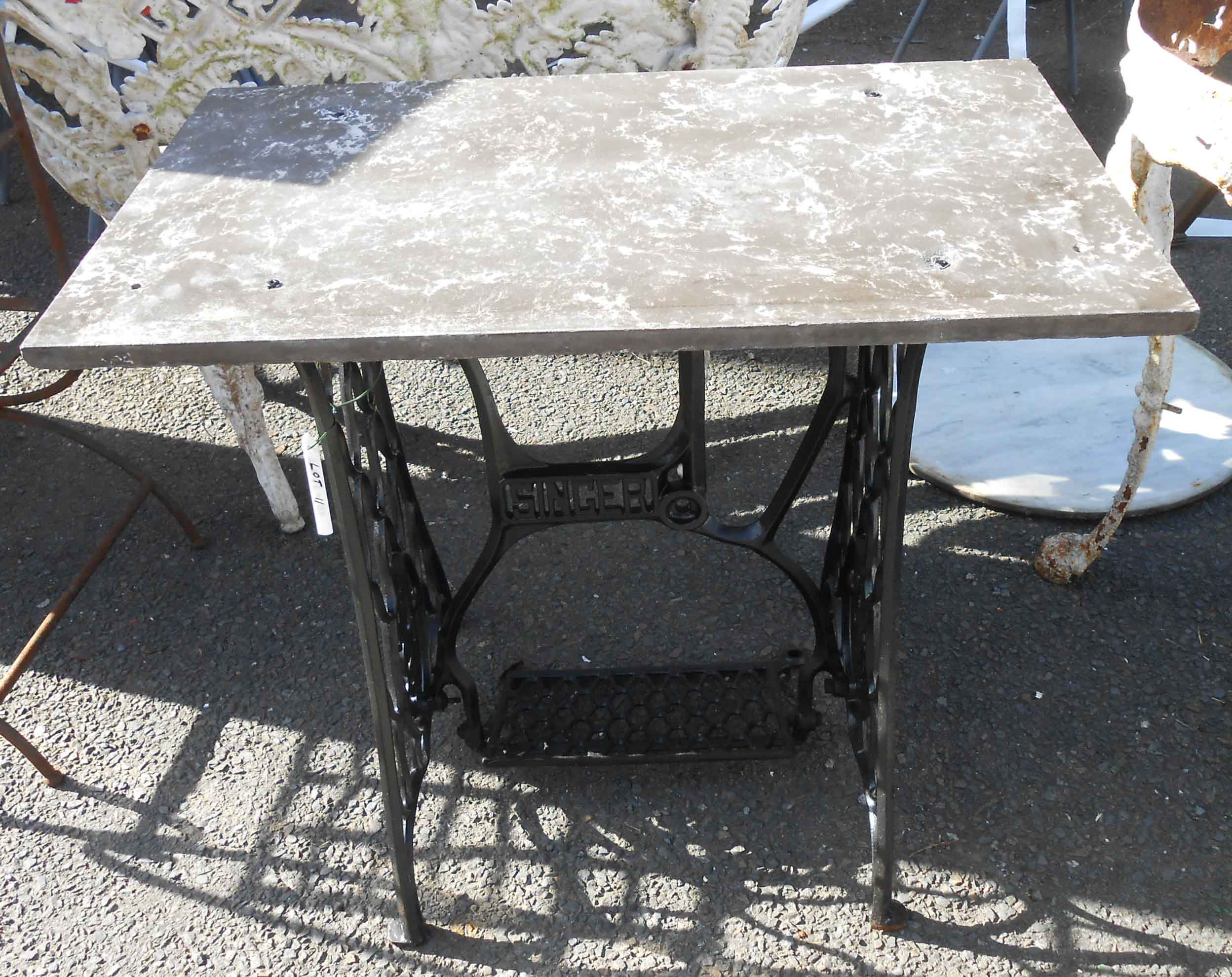 A painted cast iron Singer sewing machine treadle base with marble top