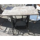 A painted cast iron Singer sewing machine treadle base with marble top