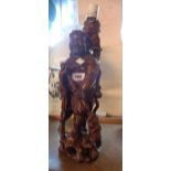 A Chinese carved wood table lamp base in the form of Shennong tugging a coin on a rope from an