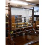 A late Victorian walnut framed swing dressing table mirror with oblong plate, set on turned supports