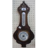 A late Victorian carved oak framed banjo barometer/thermometer with ceramic scales and aneroid works