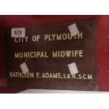 A vintage copper door plaque with inset enamel lettering City of Plymouth Municipal Midwife