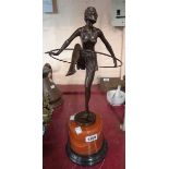 An Art Deco style bronzed lady dancing with a hoop, set on a marble column