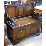 A 95cm 20th Century stained mixed wood monk's bench with flanking lion pattern supports and locker