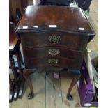 A 40cm reproduction mahogany bedside chest with drop-leaf top and three serpentine drawers, set on