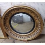 A 73cm diameter Regency gilt framed and ebonised slipped convex wall mirror some spheres and