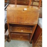 A 55cm 1930's oak student's bureau with part fitted interior and two open shelves under, set on