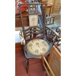 An early 20th Century stained beech framed panel back elbow chair with circular upholstered seat