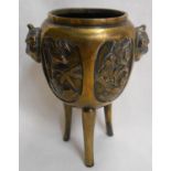 A small Oriental bronze censer with grotesque mask handles and decorative friezes, set on slender