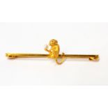 A marked 15ct yellow metal bar brooch with monkey holding a seed pearl