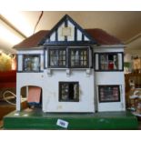 A vintage dolls house with contemporary furniture and farm animals, etc.