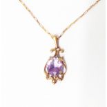 A marked 375 yellow metal amethyst drop pendant, on 9kt chain