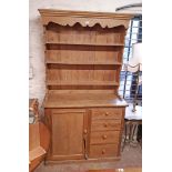 A 1.17m old waxed pine two part dresser with three shelf open plate rack over a base with flight