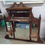 A 107cm Edwardian walnut framed overmantle mirror with multiple bevelled plates, flanking shelves