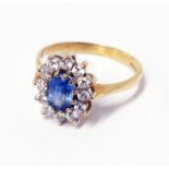 An import marked 375 gold ring, set with central pale blue oval sapphire within a tiny diamond