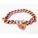 A marked 9ct rose metal kerb-link bracelet with hallmarked 9ct heart shaped padlock