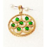 A marked yellow metal circular pendant, set with moving diopside stones