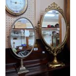 A reproduction brass framed dressing table swing mirror with pierced decoration, oval plate and