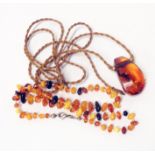 A single string of mixed colour amber beads and a polished natural amber pendant