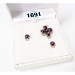 A white metal pendent and pair of ear-rings to match, set with a total of seven star rubies