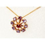 A marked 9k yellow metal pendant, set with central small ruby within a pale tanzanite border, on