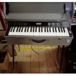 A vintage portable organ keyboard in grey case with detachable legs - retailed by Minns Music