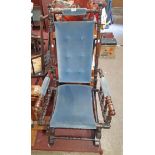 An antique stained mixed wood spindle framed American rocking chair with later blue button back