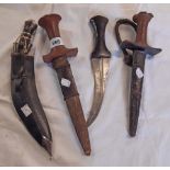 A jambiya, two Tuareg daggers with wooden handles and animal skin sheaths, and a tourist ware kukri