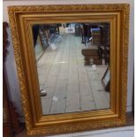 A late 20th Century decorative gilt framed bevelled oblong wall mirror - sold with a smaller