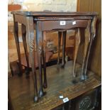 A nest of three stained mixed wood tea tables with glass inset tops, set on slender cabriole legs