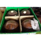 A box containing set of four wooden lawn bowls